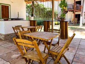 a wooden table and chairs on a patio at Wind & Sun Kite Pousada in Canoa Quebrada
