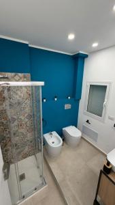 a blue bathroom with a toilet and a shower at San Lorenzo Palace in Reitani +9 photos