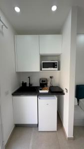 a kitchen with white cabinets and a microwave at San Lorenzo Palace in Reitani