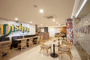 une salle à manger avec des tables et des chaises dans un restaurant dans l'établissement Verse Lite Hotel Gajah Mada, à Jakarta