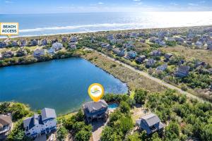 an aerial view of a house with a lake and a sign at 8198 - Still Waters in Waves