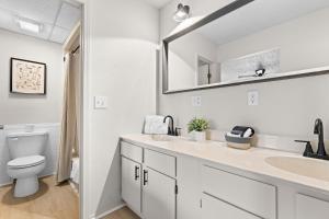 a white bathroom with a toilet and a sink at Suites at Waterside in Branson +34 photos