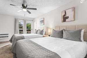 a bedroom with two beds and a ceiling fan at Suites at Waterside in Branson