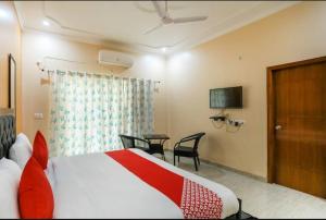 a hotel room with a bed and a table at Elite HomeZ in Greater Noida +15 photos