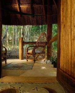 a porch of a house with a bench on it at Hotel Puerta Calakmul in Conhuas