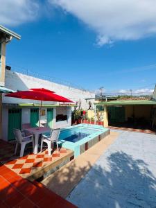 a house with a pool and a table and umbrella at Casa quinta en Girardot in Girardot