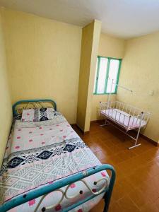 a bedroom with a bed and a crib in it at Casa quinta en Girardot in Girardot