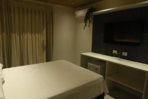 a bedroom with a white bed and a mirror at Vista do Pico in Fernando de Noronha
