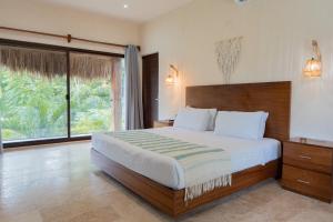 a bedroom with a large bed and a large window at Nalhá Hotel Boutique y Villas Bacalar in Bacalar +120 photos