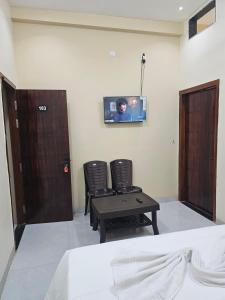 a room with two chairs and a tv on the wall at Siyara Hotel in Khamaria