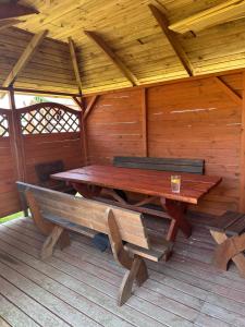 a wooden picnic table and benches in a cabin at Domki Marylkowo in Rusinowo