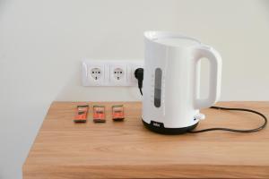 a white coffee maker sitting on a wooden counter at Erdvūs apartamentai Prie Jūros in Melnragė