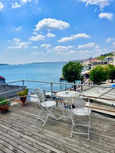 a table and chairs on a wooden deck overlooking the water at Levant Company Pension de Luxe in Istanbul