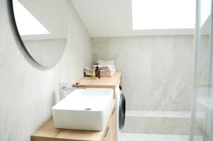 a bathroom with a white sink and a mirror at Erdvūs apartamentai Prie Jūros in Melnragė