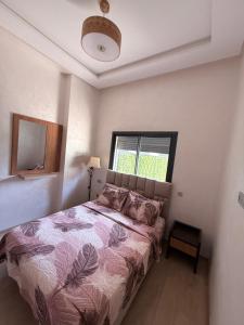 a bedroom with a bed and a window at Ocean park , for married couples and families only ,للعائلات و المتزوجين فقط Luxury fully furnished one bedroom flat next to zenata beach with five avialable swimming pool at the compound in Casablanca +16 photos