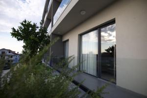 a house with a view of a balcony with glass windows at Hotel New City Tirana in Kamëz