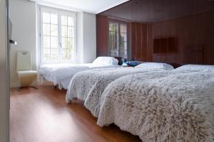 a bedroom with two beds with white blankets at Santacruz in Oviedo