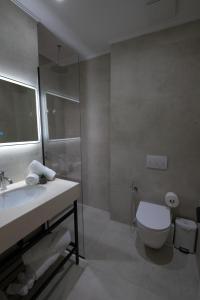 a bathroom with a toilet and a sink and a shower at Hotel New City Tirana in Kamëz +30 photos