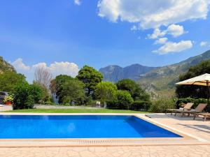 a swimming pool in a villa with mountains in the background at Milas Trojica Kotor in Kotor