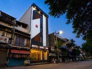 a building with a sign on the side of a street at Hotel Rose Inn in Prayagraj