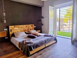 a bedroom with a large bed and a large window at Guest House Nonna Giulina, camere - Rooms in Castagnole Lanze