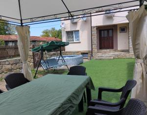 a patio with a table and chairs and a umbrella at Къща Владислав in Radevtsi