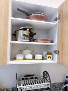 a kitchen pantry with dishes and pots and pans at Ocean park , for married couples and families only ,للعائلات و المتزوجين فقط Luxury fully furnished one bedroom flat next to zenata beach with five avialable swimming pool at the compound in Casablanca