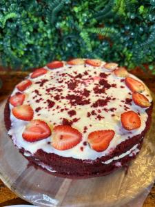 a cake with strawberries on top on a glass plate at Pousada no Sana Donna Leda in Sana