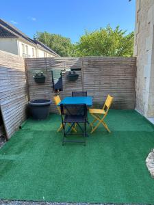 a patio with a table and chairs and a fence at Maison « La grange » climatisée in Azay-le-Rideau