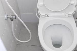 a bathroom with a white toilet with a hose at Soft stay homes in Mombasa +14 photos