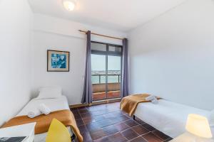 a bedroom with two beds and a balcony at HI Almada - Pousada de Juventude in Almada +70 photos