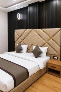 a bedroom with a large bed with a large headboard at Hotel Aarambh By Ramayana Grand-Near Ram Mandir Ayodhya in Ayodhya