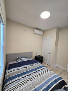 a bedroom with a bed with a blue and white striped blanket at 1 bedroom apartment in Halifax