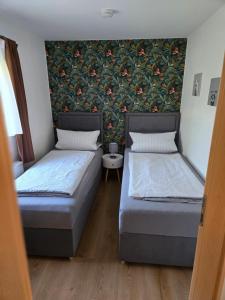 two beds in a room with a wall mural at Am Rittergut Giesenstein Gartenblick in Bad Gottleuba