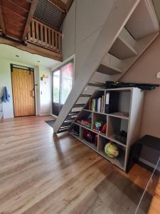 a room with a book shelf under a staircase at Boerderijcamping KiekeBoe in Maria-Hoop