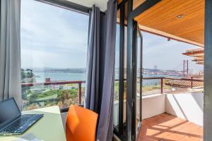 an office with a desk and a laptop on a balcony at HI Almada - Pousada de Juventude in Almada