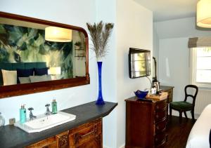 a bathroom with a sink and a mirror at The Nest Hotel & Restaurant in Petersfield