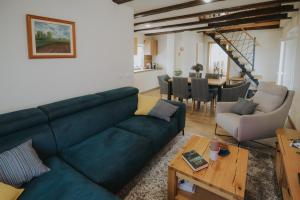 a living room with a blue couch and a dining room at Kuća za odmor Back to Bašić in Mandičevac