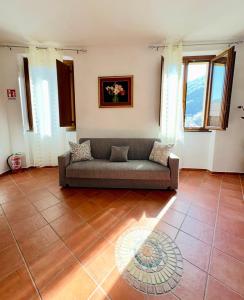 a living room with a couch on a tile floor at L'Oleandro in Maratea