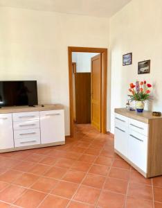 a living room with a television and a tiled floor at L'Oleandro in Maratea