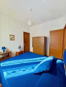 a bedroom with a blue bed with wooden cabinets at L'Oleandro in Maratea