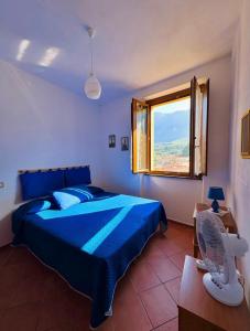 a bedroom with a blue bed and a window at L'Oleandro in Maratea