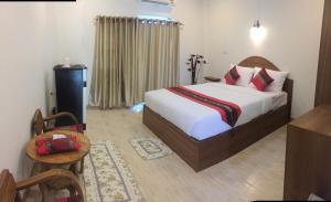 een hotelkamer met een bed, een tafel en een stoel bij Maesot Siri in Mae Sot