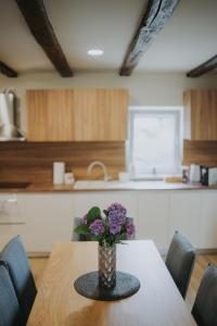 a vase of flowers on a table in a kitchen at Kuća za odmor Back to Bašić in Mandičevac +55 photos