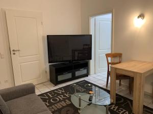 a living room with a flat screen tv and a table at Zum Schinderhannes in Waibstadt +8 photos