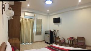 a room with a bed and a television in a room at Maesot Siri in Mae Sot