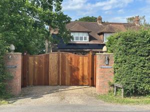 a wooden gate in front of a house at Hornbeams Annexe - Deluxe Apartment in Biddenden