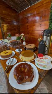 a table topped with plates with a donut on it at Pousada no Sana Donna Leda in Sana