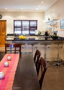 a kitchen with a long table and a counter top at Pond End Villa in Clarens