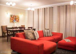 a living room with a red couch and a table at Pond End Villa in Clarens
